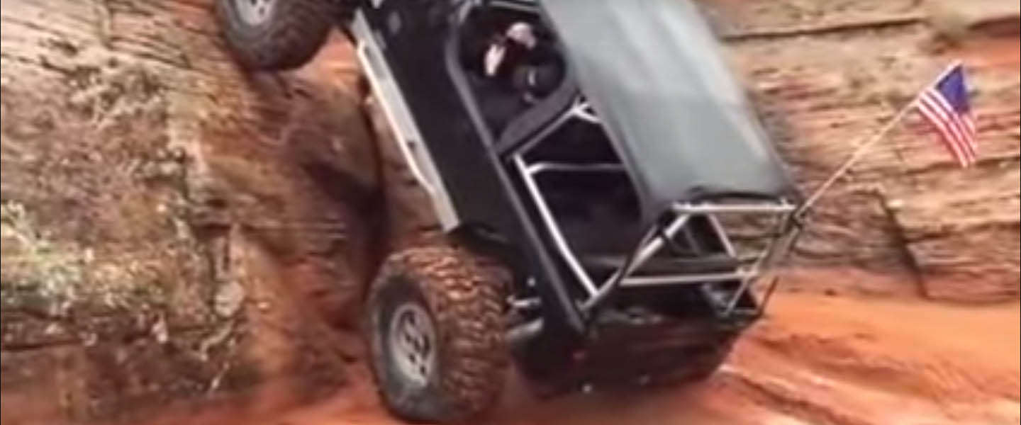Jeep klimt tegen een rotswand omhoog