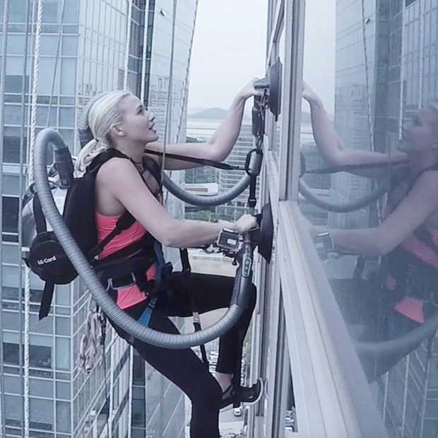 Spiderwoman beklimt wolkenkrabber met twee stofzuigers