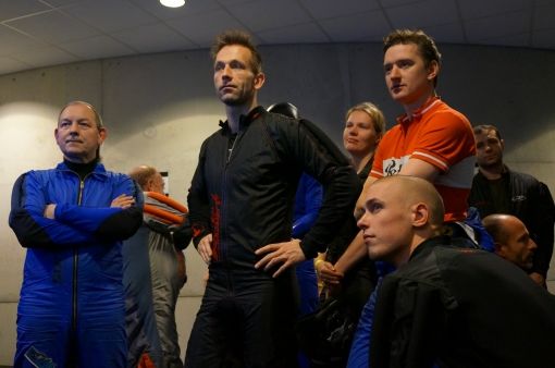 Overal hangen schermen waar de deelnemers kunnen zien wat de andere teams doen.