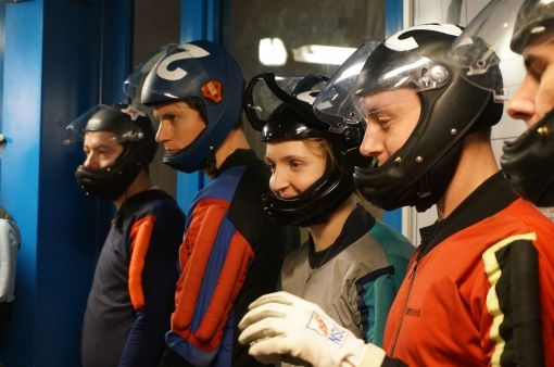 Overal hangen schermen waar de deelnemers kunnen zien wat de andere teams doen.